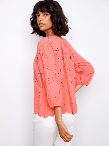 Featuring elastic cuffs, this coral top ensures a comfortable fit while maintaining chic aesthetics by Charlie B.