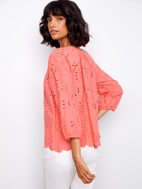 Featuring elastic cuffs, this coral top ensures a comfortable fit while maintaining chic aesthetics by Charlie B.