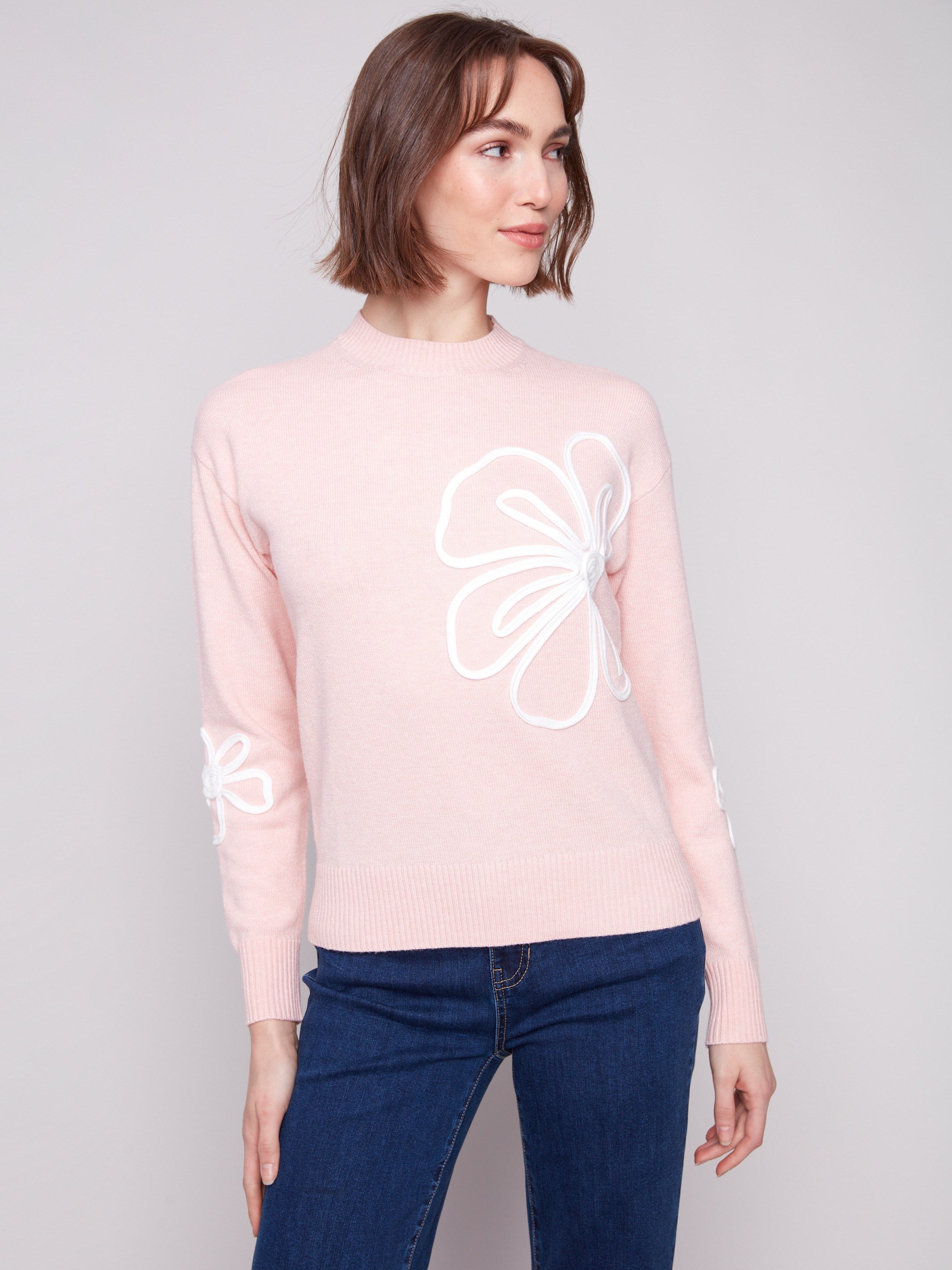 Stylish floral soutache patches embellish the sleeves, creating an eye-catching detail by Charlie B.