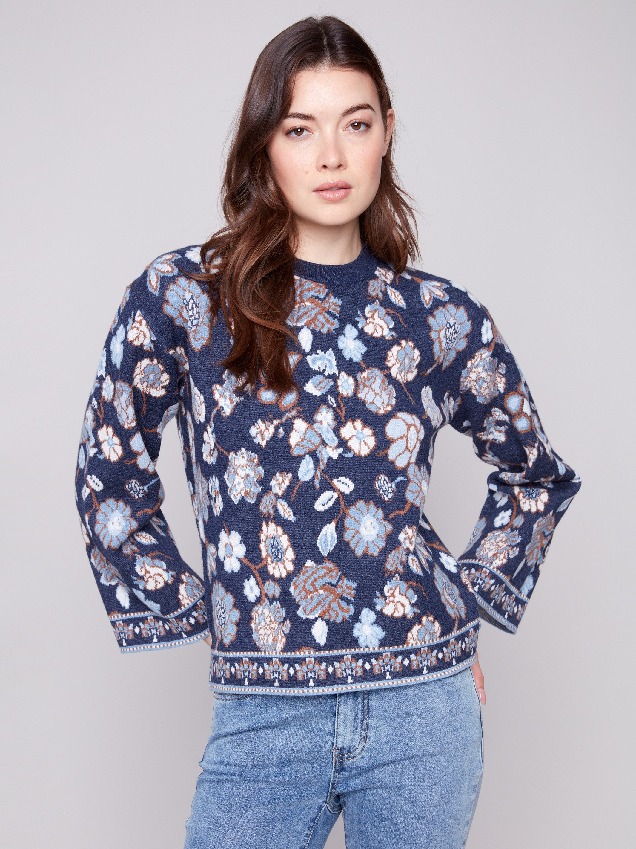 Navy blue sweater featuring dolman sleeves and a vibrant floral jacquard design, perfect for cozy elegance by Charlie B.