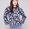 Navy blue sweater featuring dolman sleeves and a vibrant floral jacquard design, perfect for cozy elegance by Charlie B.