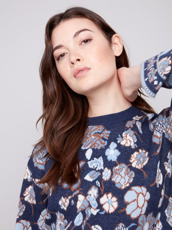 Navy blue sweater highlighted with exquisite floral jacquard detailing and versatile dolman sleeves by Charlie B.