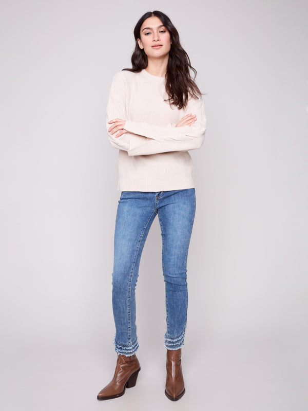 This heather oat sweater showcases elegant cable details on the sleeves, perfect for a chic look by Charlie B.