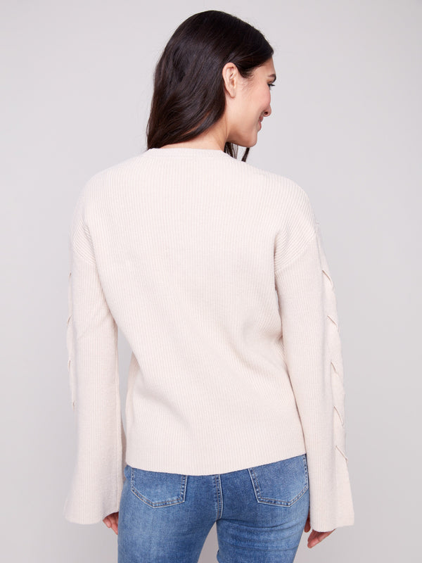 Soft oat sweater with drop shoulders and intricate sleeve design, offering both comfort and style by Charlie B.