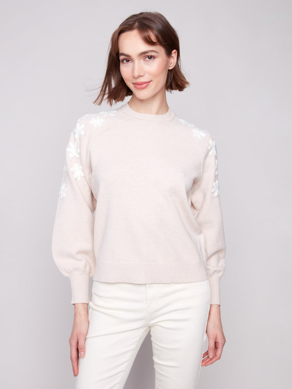 Oat sweater with white floral embroidery, highlighting the crew neck design for a classic look by Charlie B.