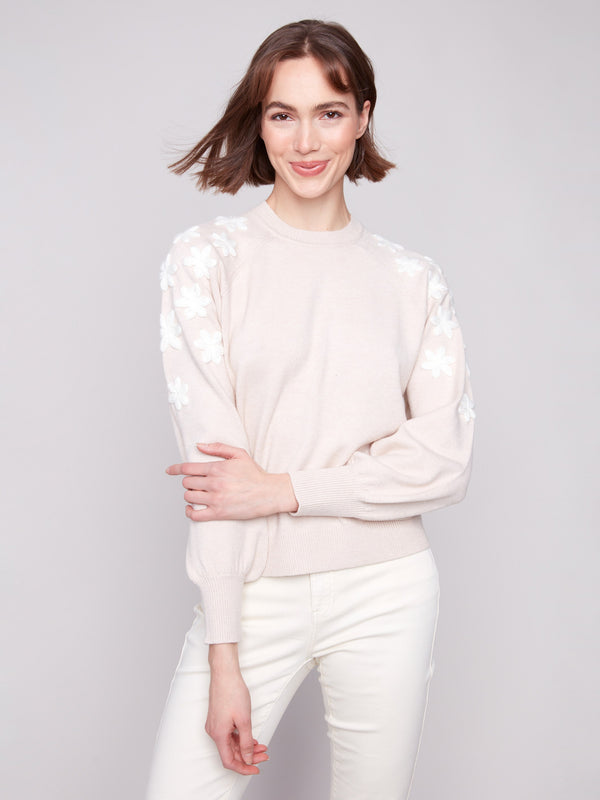 Elegant crew neck sweater adorned with intricate white floral details on the shoulders by Charlie B.