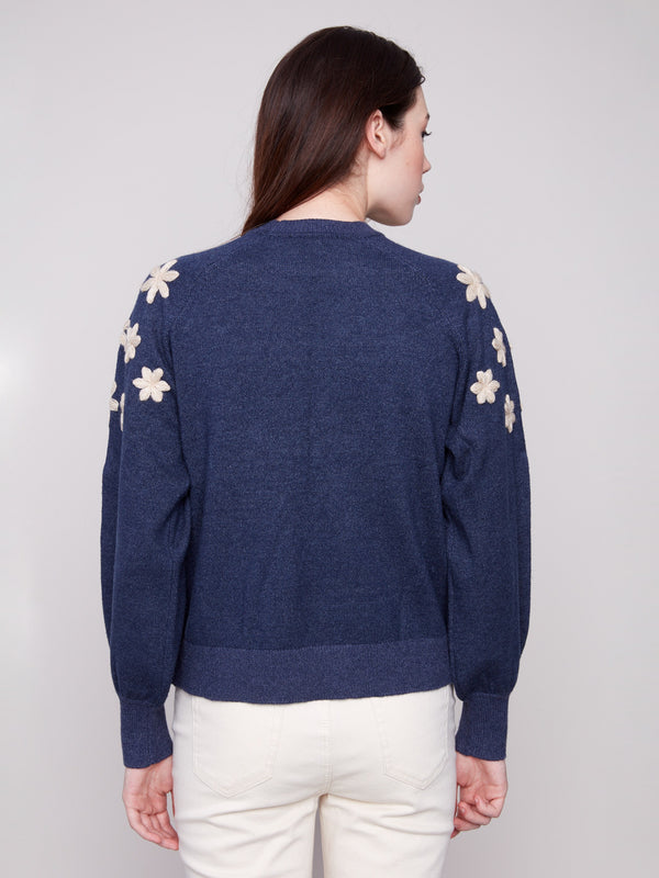 Heather denim sweater showcasing unique raglan puff sleeves and delicate floral accents on the shoulders by Charlie B.