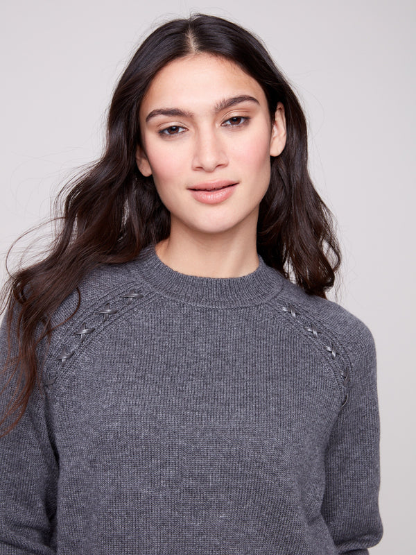 Charcoal sweater highlighted by faux leather detail at the armhole, adding a modern touch to the classic look by Charlie B.