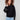 Elegant black sweater with a classic crew neck design and pearl embellishments, adding a touch of sophistication by Charlie B.