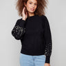 Elegant black sweater with a classic crew neck design and pearl embellishments, adding a touch of sophistication by Charlie B.