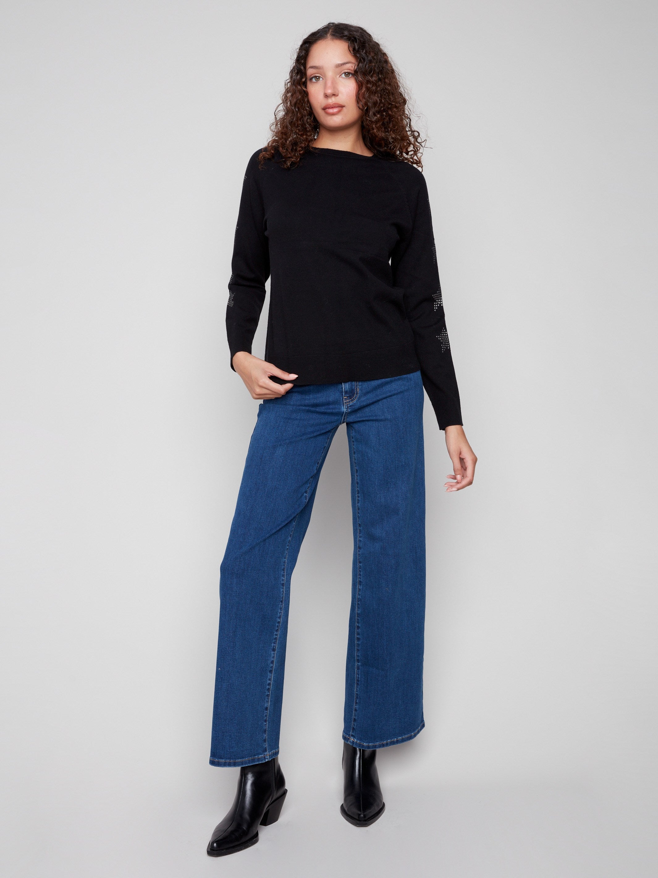 Stylish black crew neck sweater with distinctive star stud accents on the sleeves, adding flair to any outfit. By Charlie B.