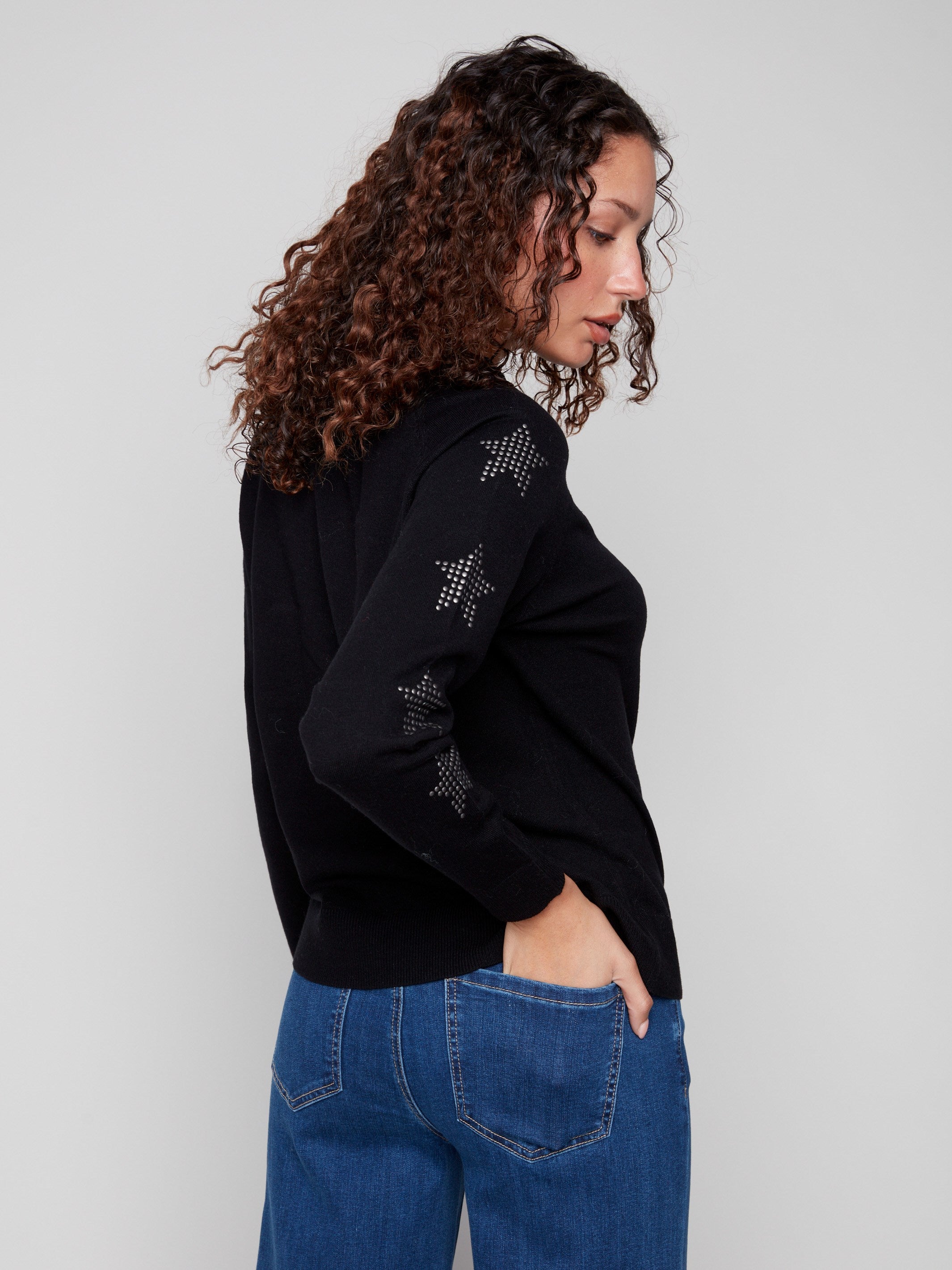 Chic black sweater adorned with sparkling star studs on the sleeves, offering a unique touch to your wardrobe. By Charlie B.