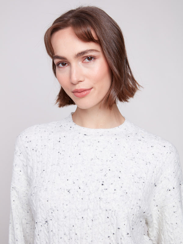 Cozy white sweater with a speckled pattern and crew neck, highlighting its wide cuffs by Charlie B.