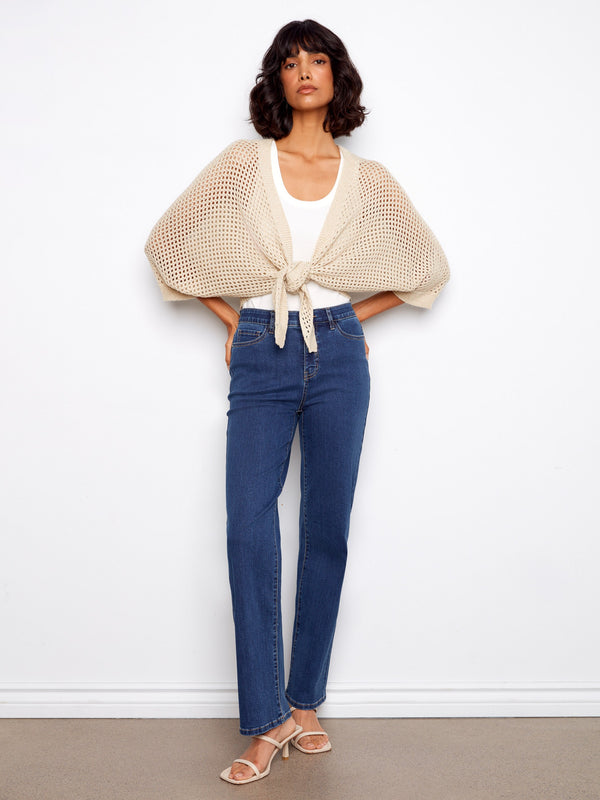 Open-knit shrug in beige featuring an adjustable tie-front design and elbow-length sleeves for versatile styling by Charlie B.