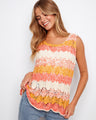 This crochet tank top in apricot features a stylish scoop neckline, perfect for casual outings. Designed by Charlie B.
