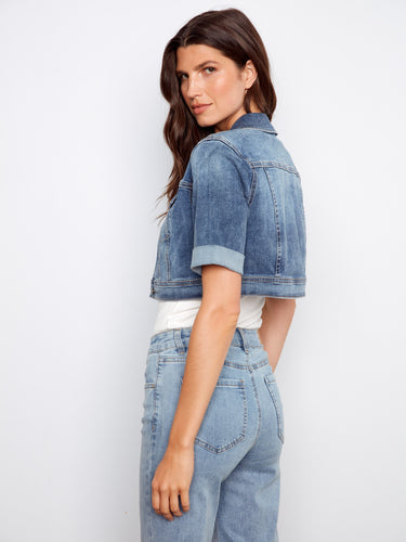 Complete your outfit with this modern cropped denim jacket, boasting a sleek button closure and stylish details by Charlie B.