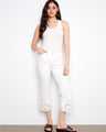White cropped pants with a flared fit and intricate laser-cut lace hem, perfect for casual elegance by Charlie B.