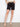 These black shorts feature slash pockets for added convenience, styled with a beige belt and matching top by Charlie B.