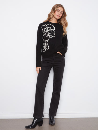 Classic black sweater accented with intricate floral design, finished off with a crew neckline and ribbed hem by Charlie B.
