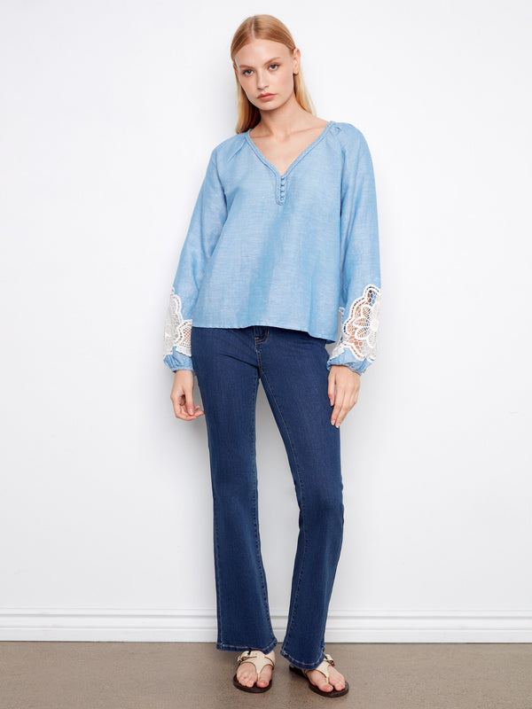 Chic blue top with decorative buttons down the front, styled effortlessly with denim. By Charlie B.