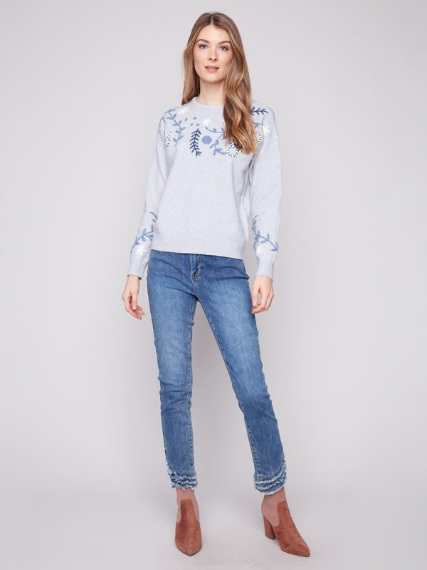 Elegant drop shoulder design on a heather grey sweater with floral details by Charlie B.