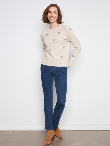 This sweater showcases an intricate embroidered floral design, adding a touch of elegance. By Charlie B.