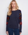 Sweater featuring a classic crew neck with an intricate embroidered floral design that adds a touch of elegance. By Charlie B.