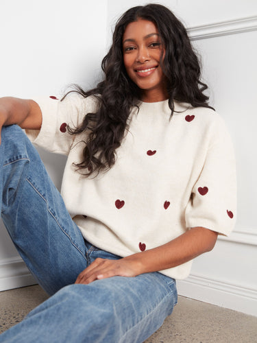 Embroidered hearts add a playful and romantic detail to this chic sweater, enhancing its visual appeal. By Charlie B.