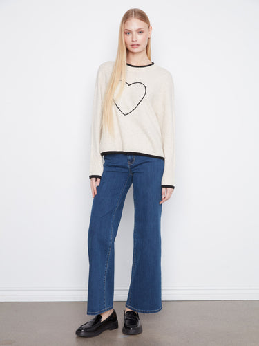 This sweater showcases charming heart embroidery on the front, adding a touch of whimsy to your wardrobe essentials. By Charlie B.