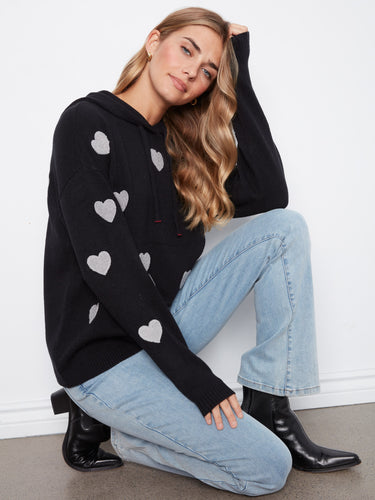 Trendy heart-themed black hoodie showcasing ribbed cuffs and hem for added texture and warmth. By Charlie B.