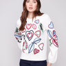 Ecru sweater adorned with hearts and leaves embroidery, showcasing a relaxed fit for ultimate comfort by Charlie B.