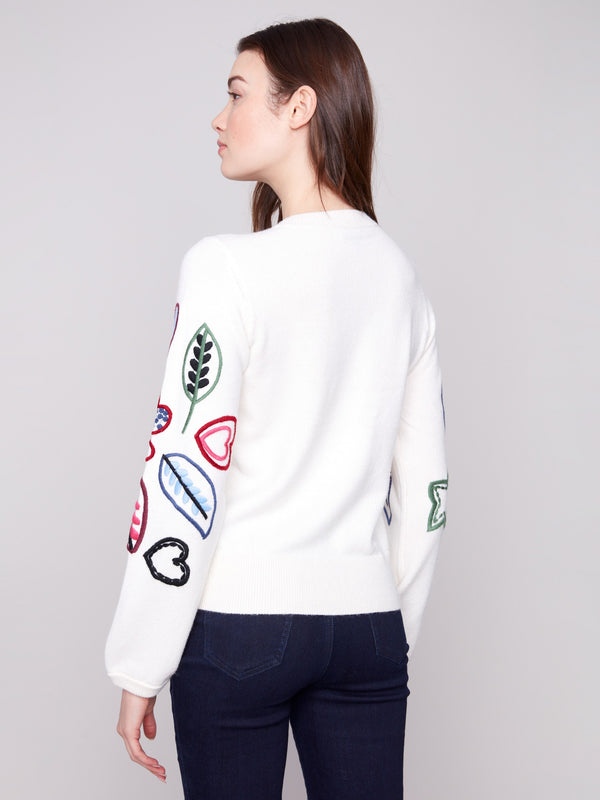 Ecru sweater embellished with colorful hearts and leaves, offering a cozy relaxed fit for any occasion by Charlie B.