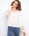 White linen blend blouse featuring a braided V-neck and intricate embroidered sleeves for a chic look by Charlie B.