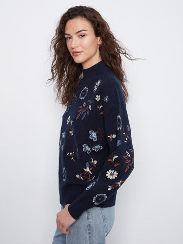 Stay warm in this navy sweater featuring long sleeves and delicate floral patterns that enhance its elegance by Charlie B.