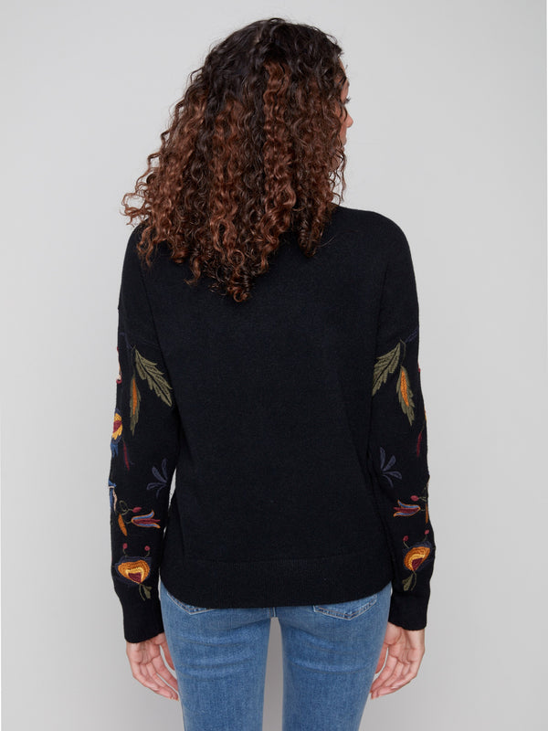 Fashionable black sweater showcasing ribbed cuffs and hem for added texture by Charlie B.