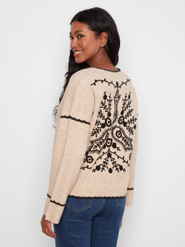 This sweater showcases an intricate embroidered back design that adds elegance and flair to your outfit. A unique piece by Charlie B.