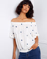 Stylish off-the-shoulder top adorned with blue floral embroidery and elastic hem by Charlie B.