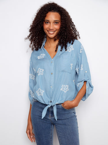 Charming blue blouse with embroidered flowers, designed with a collared V-neckline and rolled-up sleeves by Charlie B.