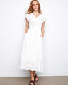 White dress with V-neck and elastic empire waist, featuring hidden pockets for practicality by Charlie B.