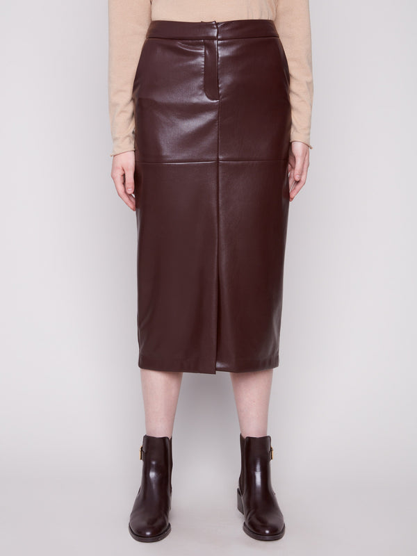 Sophisticated cabernet faux leather midi skirt with a slit front hem, styled with a beige top and brown boots by Charlie B.