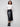 Black faux leather midi skirt featuring side pockets, paired with a white top and black ankle boots by Charlie B.