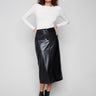 Black faux leather midi skirt featuring side pockets, paired with a white top and black ankle boots by Charlie B.