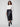 Elegant black faux leather skirt with a stylish slit front hem, matched with a white top and black boots by Charlie B.