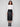 Sophisticated black faux leather skirt showcasing its midi length, combined with a crisp white top and stylish boots by Charlie B.