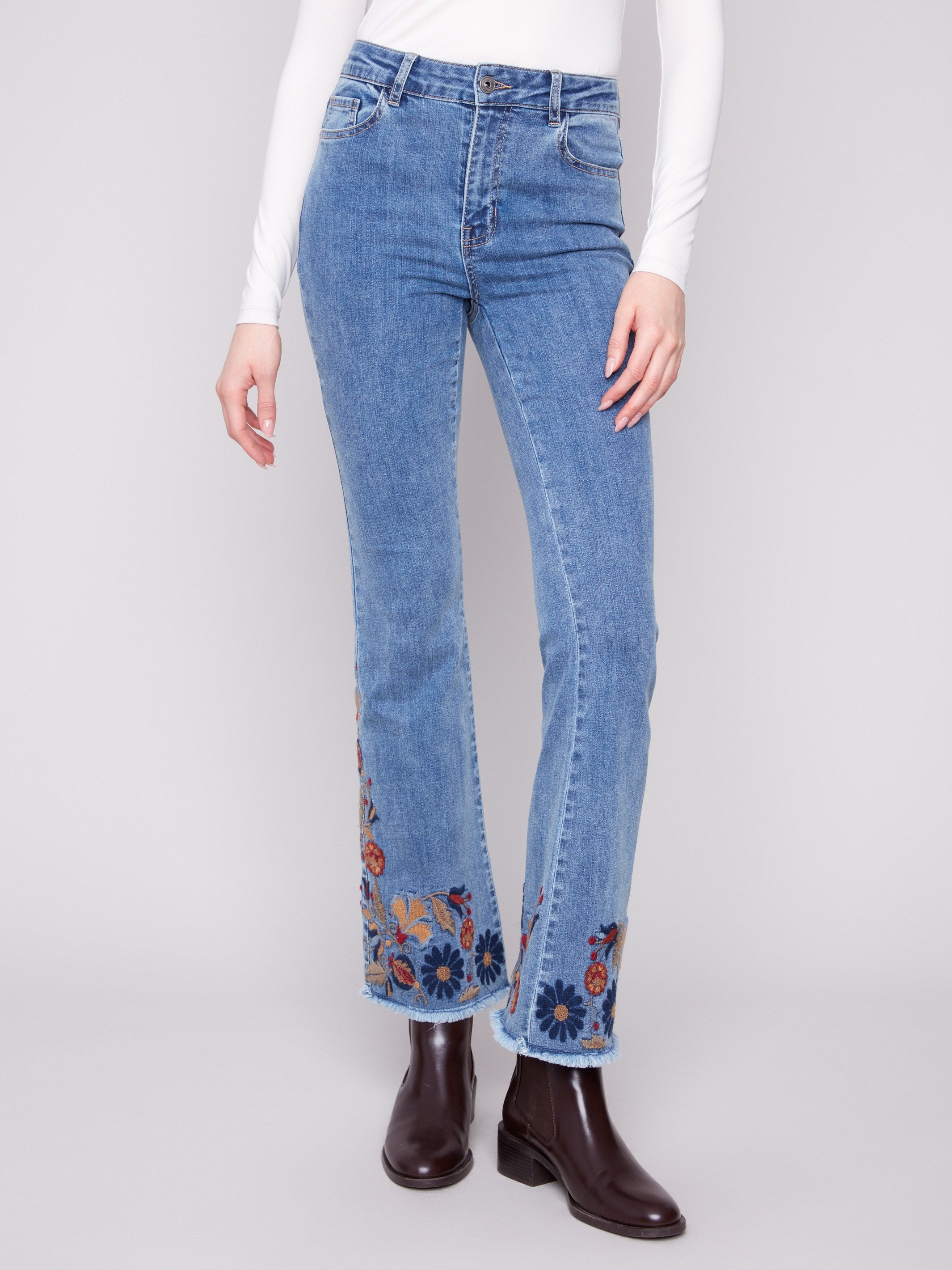 These stretch denim jeans feature colorful floral accents, combining comfort with fashion by Charlie B.