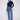 Medium blue jeans with a five-pocket design and a dark top, offering both style and practicality by Charlie B.