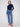 Medium blue jeans with a five-pocket design and a dark top, offering both style and practicality by Charlie B.
