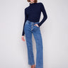 Medium blue jeans with a five-pocket design and a dark top, offering both style and practicality by Charlie B.