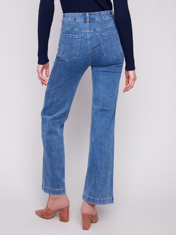 Stylish flare fit jeans in medium blue denim paired with an elegant dark top for versatile looks by Charlie B.