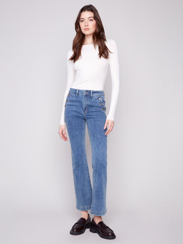 Medium blue jeans featuring a flare leg design and crafted from stretch denim, worn by a model, designed by Charlie B.